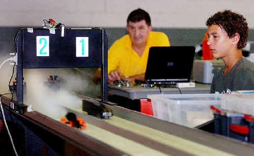 Chief organiser of the CO2 dragster competition Keith Holledge and official Ryan Knight keep their eyes on the dragsters as they blast out to an equivalent speed of 60kmh. Chief organiser of the CO2 dragster competition Keith Holledge and official Ryan Knight keep their eyes on the dragsters as they blast out to an equivalent speed of 60kmh.